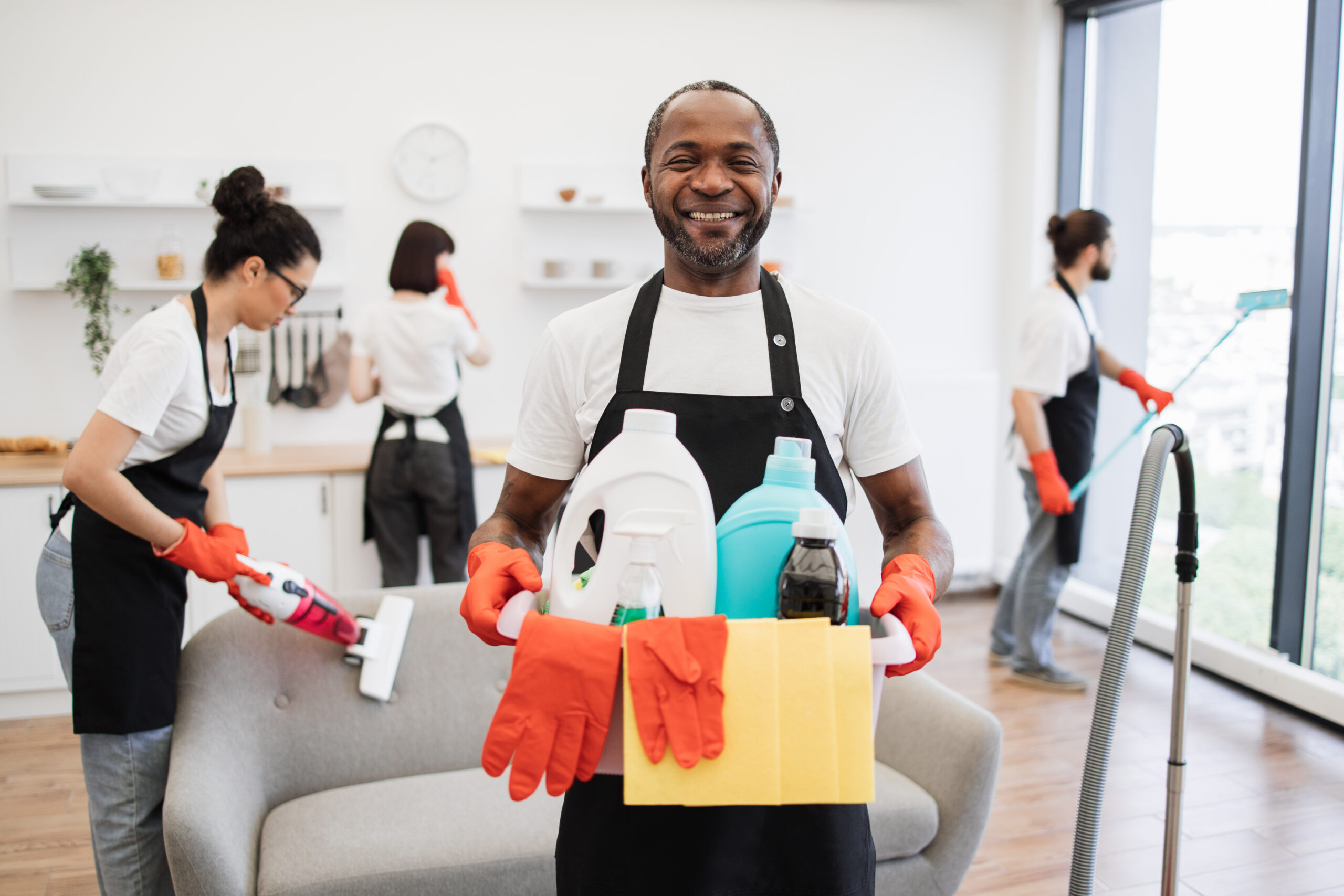 african man professional cleaning worker holding a bucket with detergents.